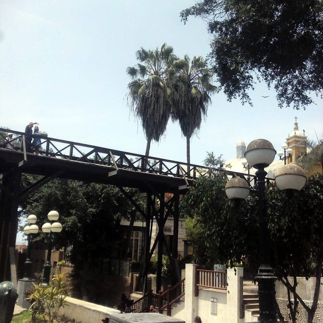 Puente de los Suspiros con palmeras y la Ermita de Barranco al fondo